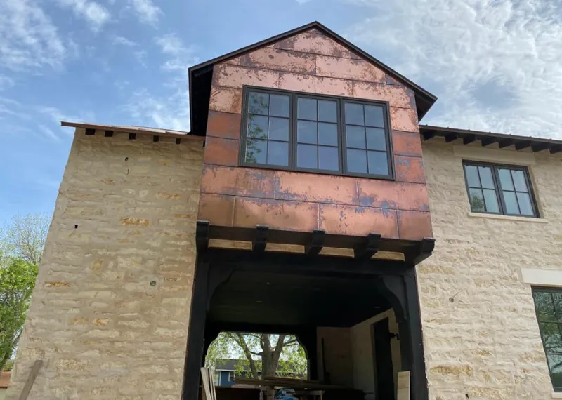 Copper metal panel facade on a stone building for Skylight Installation in Lake Villa
