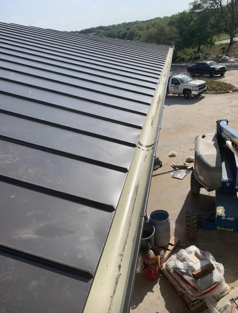 Standing seam panel and gutter detail on a metal roofing jobsite in Lake Villa